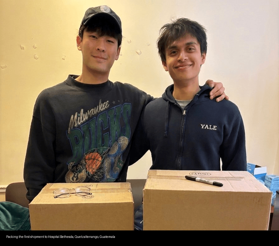 Josh and Sebastian packing boxes labeled Hospital Bethesda, Yale University
